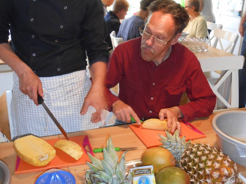 Der Koch und ein Bewohner beim Obstschneiden