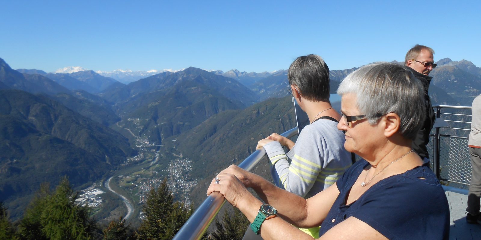 Zwei Bewohnerinnen stehen auf einer Aussichtsplattform und schauen über die Berge